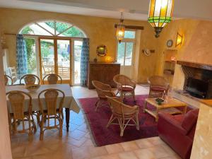 ein Wohnzimmer mit einem Tisch, Stühlen und einem Sofa in der Unterkunft Mas des Lavandes - 3 gîtes de charme au calme avec grande piscine en Drôme-Provençale in Suze-la-Rousse