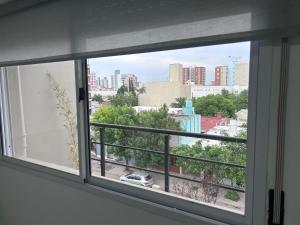 une fenêtre avec vue sur la ville dans l'établissement Apart Luro IV, à Santa Rosa