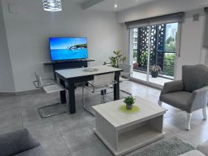 uma sala de estar com uma mesa e uma televisão na parede em Apart Luro IV em Santa Rosa