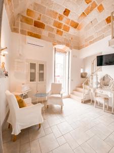 Elle comprend un salon doté d'un mobilier blanc et d'un plafond en pierre. dans l'établissement Karen House B&B, à Polignano a Mare
