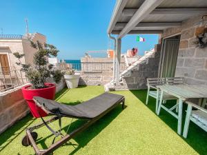 a patio with a chair and a table on a roof at Karen House B&B in Polignano a Mare