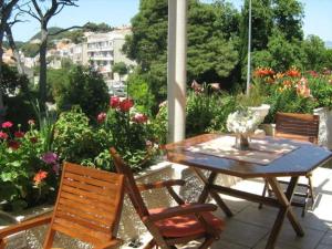 una mesa y sillas en un patio con flores en House Boninovo, en Dubrovnik