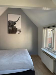 a bedroom with a bed with a picture of a bull at De Vrije Vogel in Egmond aan Zee