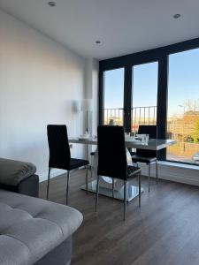 uma sala de estar com uma mesa, cadeiras e janelas em Spacious 2BR with balcony in Brentwood em Brentwood