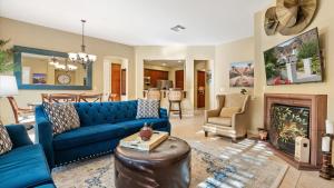 Una sala de estar con un sofá azul y una chimenea. en LV313 Legacy Villas Gem: 1-Story Mountain Views, en La Quinta