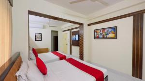 a bedroom with a white bed with red pillows at Hotel Golden Inn Dhaka in Dhaka