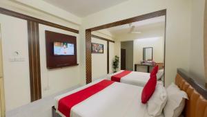 a bedroom with two beds and a flat screen tv at Hotel Golden Inn Dhaka in Dhaka