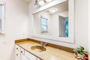 une salle de bain avec un lavabo et un miroir dans l'établissement Blue Goose, à Folly Beach 15 autres photos