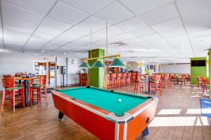 a pool table in a room with tables and chairs at Bay Watch 1941 in Myrtle Beach
