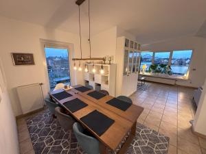 uma sala de jantar com uma mesa e algumas janelas em Village Vista Penthouse em Wesseling