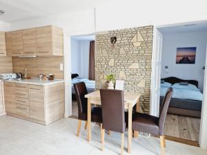 a kitchen and dining room with a table and a bedroom at Balaton Apartman Füred in Balatonfüred
