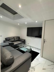 een woonkamer met banken en een flatscreen-tv bij Luxury Travis House in Burnley