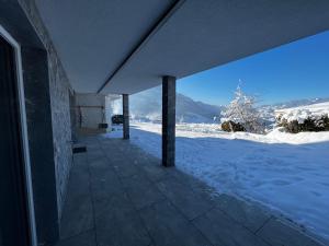 un bâtiment avec de la neige au sol à côté d'un bâtiment dans l'établissement Mountain Home Alpendorf, à Plankenau