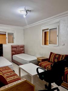 uma sala de estar com um sofá e uma cama em Dar al anbar em Rabat