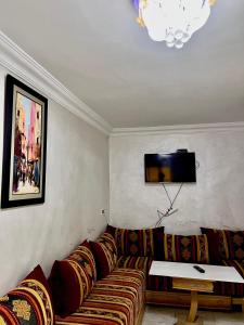 uma sala de estar com um sofá e uma televisão na parede em Dar al anbar em Rabat