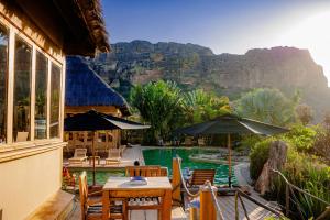 a resort with a pool with tables and umbrellas at Satrana Lodge in Ranohira