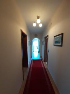 un largo pasillo con una alfombra roja y una puerta en Apartment Nadine Mljet, en Okuklje