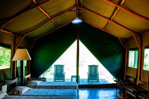 een kamer met 2 bedden in een groene tent bij Satrana Lodge in Ranohira