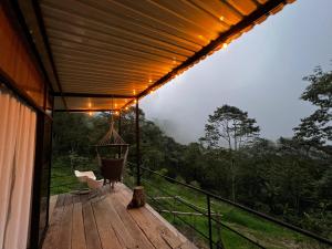 una terraza con un columpio y una silla en Cabaña Aurora de Silvania, en Silvania