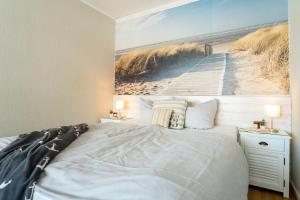 een slaapkamer met een bed met een foto van een strand bij Haus-Steinwarder-7-Wohnung-Strandbude-17 in Heiligenhafen