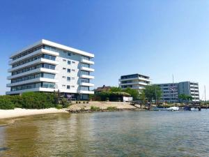 een gebouw naast een waterlichaam met gebouwen bij Haus-Steinwarder-7-Wohnung-Strandbude-17 in Heiligenhafen