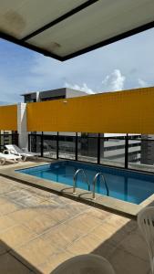 une piscine sur le toit d'un bâtiment dans l'établissement Apt temporada em Ponta Verde, à Maceió
