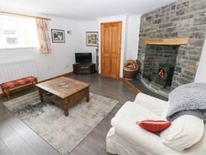 Una sala de estar con un sofá y una chimenea. en Corran Cottage, en Carmarthen