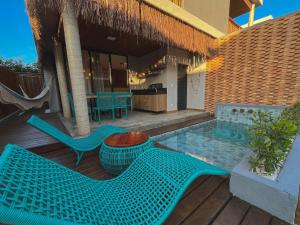 a patio with two blue chairs and a pool at Villa Sapê 9 in São Miguel dos Milagres