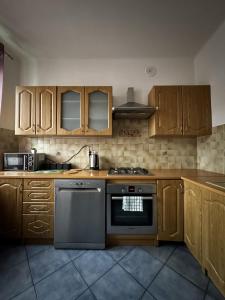 cocina con armarios de madera y horno con fogones en Home&Home Mokotów, en Varsovia
