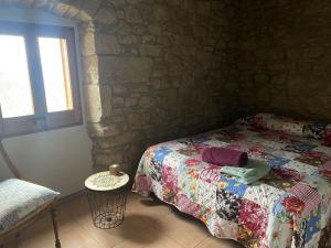 um quarto com uma cama numa parede de pedra em Angrill em Lladurs