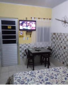 una camera da letto con tavolo e TV a parete di Pousada em Fazenda Nova Dona Rosy a Fazenda Nova
