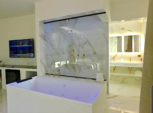 W białej łazience znajduje się umywalka i lustro. w obiekcie Suite Èlite Rooms w mieście Peschici