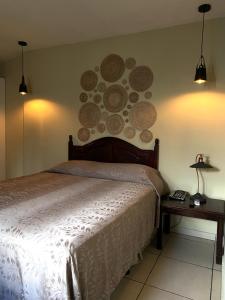 um quarto com uma cama e uma parede com placas em Hotel Andoria em San Salvador