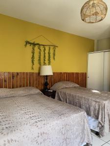 two beds in a room with yellow walls at Hotel Andoria in San Salvador