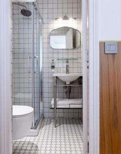 La salle de bains est pourvue d'un lavabo et d'un miroir. dans l'établissement Escapade Familiale à Grenelle, à Paris