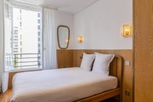 a bed in a room with a large window at Escapade Familiale à Grenelle in Paris