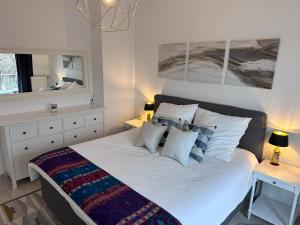 um quarto com uma cama grande com lençóis brancos e almofadas em Village Vista Penthouse em Wesseling