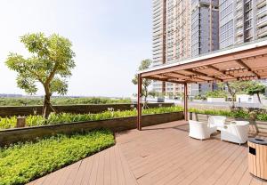 a patio with white chairs and a pavilion at Comfort and Luxury Private Room at Goldcoast PIK in Jakarta