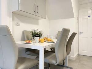 Immaculate 5 Bedroom House في روكينجهام: طاولة طعام بيضاء وكراسي في مطبخ