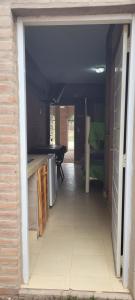 an open door to a room with a kitchen and a bedroom at Departamentos “Don Ramon” in Villa Cura Brochero