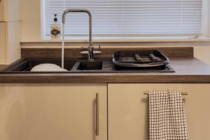 un bancone della cucina con lavandino e lavandino di Immaculate 5 Bedroom House a Rockingham