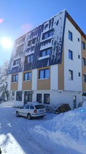 ヤホリナにあるApartmani RISの建物の前に車が駐車されている