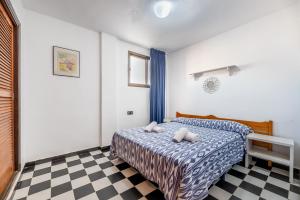 ein Schlafzimmer mit einem Bett und einem karierten Boden in der Unterkunft Apartamento Bilo 301 in Es Pujols