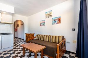 ein Wohnzimmer mit einem Sofa und einem Tisch in der Unterkunft Apartamento Bilo 301 in Es Pujols