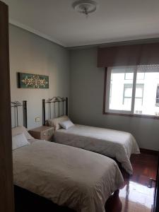a bedroom with two beds and a window at El Descanso in Ourense
