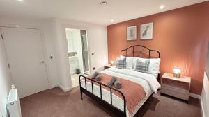 a bedroom with a large bed with an orange wall at Shoreditch Apartments by Sleepy in London