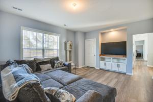 uma sala de estar com um sofá e uma televisão de ecrã plano em Quiet Bayfront Hayes Home with Deck and Private Beach! em Yorktown