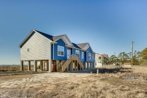uma casa azul e branca num campo em Quiet Bayfront Hayes Home with Deck and Private Beach! em Yorktown