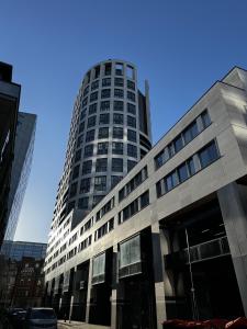 a tall building in front of a blue sky at Shoreditch Apartments by Sleepy in London