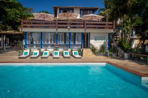 una casa con piscina di fronte a una casa di Pousada Lestada by Latitud Hoteles a Búzios